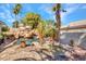 The backyard features a stunning pool with rock waterfall, grotto, table, and mature landscaping at 125 Firecreek Cir, Las Vegas, NV 89107