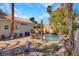 The backyard features a stunning pool with rock waterfall, grotto, table, and mature landscaping at 125 Firecreek Cir, Las Vegas, NV 89107
