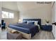 Virtually staged bedroom featuring large bed with blue headboard, blue accent chair, and natural lighting at 1400 Cottonwood Pl, Las Vegas, NV 89104