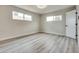 Bright bedroom with wood-look flooring, two windows, and a white door at 1400 Cottonwood Pl, Las Vegas, NV 89104