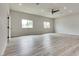 Spacious bedroom featuring two windows, light wood flooring, and modern ceiling fan at 1400 Cottonwood Pl, Las Vegas, NV 89104
