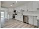 Bright kitchen boasts white cabinetry, stainless steel appliances, and light wood floors for a modern touch at 1400 Cottonwood Pl, Las Vegas, NV 89104