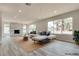 Staged living room showcases a stylish couch, area rug, and views of palm trees outside the large windows at 1400 Cottonwood Pl, Las Vegas, NV 89104