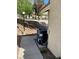 Side view of house with AC unit on patio and desert landscaping featuring stone, shrubs, and trees at 2260 Rugged Mesa Dr, Laughlin, NV 89029