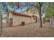 Private backyard showcasing the home's exterior, featuring a mature tree and gated access at 2649 Heathrow St, Las Vegas, NV 89135