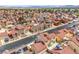An aerial view showcases an expansive neighborhood with numerous homes, tree-lined streets, and mountain views at 2727 Scotch Heather St, Las Vegas, NV 89142
