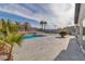 Spacious backyard patio area featuring a swimming pool, palm trees, concrete border, and privacy wall at 2749 Horseshoe Dr, Las Vegas, NV 89120