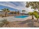 Beautiful backyard swimming pool with concrete surround and desert landscaping and mature palm trees at 2749 Horseshoe Dr, Las Vegas, NV 89120