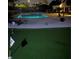 Night view of a home's backyard pool and putting green, complete with flags at 2749 Horseshoe Dr, Las Vegas, NV 89120