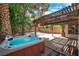 Backyard featuring a relaxing hot tub, covered wooden patio, and gravel landscape at 2819 Prickley Pear Dr, Henderson, NV 89074