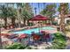 Community pool with comfortable lounge chairs, seating area, and lush tropical landscaping at 2975 Bluegrass Ln # 811, Henderson, NV 89074