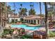Community pool and clubhouse with red tile roof surrounded by mature trees and lounge chairs at 2975 Bluegrass Ln # 811, Henderson, NV 89074