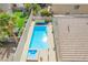 A home's backyard with a pool, hot tub, lush plants, and artificial grass at 3057 Sunrise Heights Dr, Henderson, NV 89052