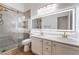 Bathroom with double vanity, backlit mirror, and glass shower with brushed gold fixtures at 3057 Sunrise Heights Dr, Henderson, NV 89052