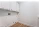 Bright laundry room with white cabinets, wood look floors, and utility hookups at 3057 Sunrise Heights Dr, Henderson, NV 89052