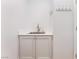 Laundry room with a stainless steel sink, a white cabinet, and a hook rack at 3057 Sunrise Heights Dr, Henderson, NV 89052