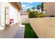 Side yard with synthetic grass, a walkway, and an exterior utility panel at 3057 Sunrise Heights Dr, Henderson, NV 89052