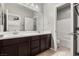 Bathroom with double sinks, dark wood cabinets and a view to the toilet and bathtub at 3062 Echoed Rondel Ln, Henderson, NV 89044