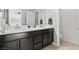 Elegant bathroom featuring a double vanity with dark cabinets and modern fixtures at 3062 Echoed Rondel Ln, Henderson, NV 89044