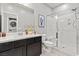Modern bathroom with a double vanity, glass-enclosed shower, and a view of the laundry area at 3062 Echoed Rondel Ln, Henderson, NV 89044