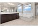 Luxurious bathroom featuring a soaking tub, walk-in shower, dual sink vanity, and large mirror at 3062 Echoed Rondel Ln, Henderson, NV 89044