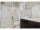 Bright bathroom featuring a glass shower, dark cabinets, and a single sink at 3062 Echoed Rondel Ln, Henderson, NV 89044