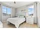 Well-lit bedroom with wood floors, neutral walls, two windows, white furniture and nice decor at 3062 Echoed Rondel Ln, Henderson, NV 89044
