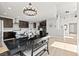 Inviting dining area with a modern chandelier, open to the kitchen with sleek countertops and stainless appliances at 3062 Echoed Rondel Ln, Henderson, NV 89044