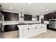 Modern kitchen with dark cabinets, stainless steel appliances, and center island at 3062 Echoed Rondel Ln, Henderson, NV 89044