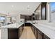 Modern kitchen features stainless appliances, dark cabinetry, and a large island with quartz countertops at 3062 Echoed Rondel Ln, Henderson, NV 89044