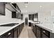 Modern kitchen features dark cabinetry, stainless steel appliances, and a large island with white countertops at 3062 Echoed Rondel Ln, Henderson, NV 89044