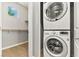 Convenient laundry area featuring a stacked washer and dryer with wood flooring and storage space at 3062 Echoed Rondel Ln, Henderson, NV 89044