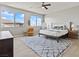 Bright main bedroom featuring a ceiling fan, two windows, a large rug, and modern furniture at 3062 Echoed Rondel Ln, Henderson, NV 89044
