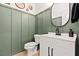 Stylish powder room with green wainscoting, modern vanity, and elegant fixtures at 3062 Echoed Rondel Ln, Henderson, NV 89044