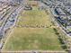 Aerial view showcasing a well-maintained soccer field in a community with residential houses and mature trees at 3062 Echoed Rondel Ln, Henderson, NV 89044