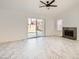Bright living room featuring marble-like tile flooring, ceiling fan, fireplace, and sliding glass doors to the yard at 3314 Astoria Dr, Las Vegas, NV 89121