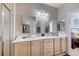 Well-lit bathroom with dual sinks, framed mirrors and a walk-in closet at 3335 American Mustang Ct, Las Vegas, NV 89122