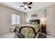 Comfortable bedroom features a ceiling fan, earth-tone walls, and a window with bright natural light at 3335 American Mustang Ct, Las Vegas, NV 89122