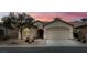 Inviting single-story home featuring a two-car garage, desert landscaping, and a covered entry way, perfect for easy living at 3335 American Mustang Ct, Las Vegas, NV 89122