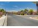 Wide shot of community's gated entrance, stone columns, and well-maintained landscaping at 3335 American Mustang Ct, Las Vegas, NV 89122