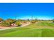 Scenic view of the golf course featuring lush green fairways, mature trees, and distant mountain views at 3335 American Mustang Ct, Las Vegas, NV 89122