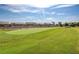 Well-manicured golf course with expansive green fairways and residential homes in the background under a partly cloudy sky at 3335 American Mustang Ct, Las Vegas, NV 89122