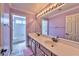 Well-lit bathroom featuring double sinks, a large mirror, and a separate toilet and shower area for convenience at 3525 Dover Bay St, Las Vegas, NV 89129