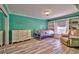 Bright bedroom with wood-look flooring, built-in shelves, a window seat, and a decorative scripture decal on the wall at 3525 Dover Bay St, Las Vegas, NV 89129