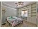 Comfortable bedroom featuring built-in bookshelves, a ceiling fan, and a bright window at 3525 Dover Bay St, Las Vegas, NV 89129