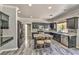 Well-lit kitchen featuring stainless appliances, granite countertops, an island with seating, and gray laminate flooring at 3525 Dover Bay St, Las Vegas, NV 89129