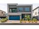 Modern two-story home featuring a blue garage door, minimalist landscaping, and a small second story balcony at 363 Terrill Ave, Las Vegas, NV 89183