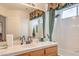 Bright bathroom showcases tiled walls, a shower with decorative curtains, vanity with a sink, and window with blinds at 3735 Morning Canyon St, Las Vegas, NV 89147