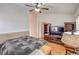 Bedroom featuring wood floors, ceiling fan, a bed, and a TV stand with shelving units for storage at 3735 Morning Canyon St, Las Vegas, NV 89147