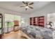 Bedroom with wood floors, ceiling fan, large windows with blinds, and built-in wooden bookshelves at 3735 Morning Canyon St, Las Vegas, NV 89147